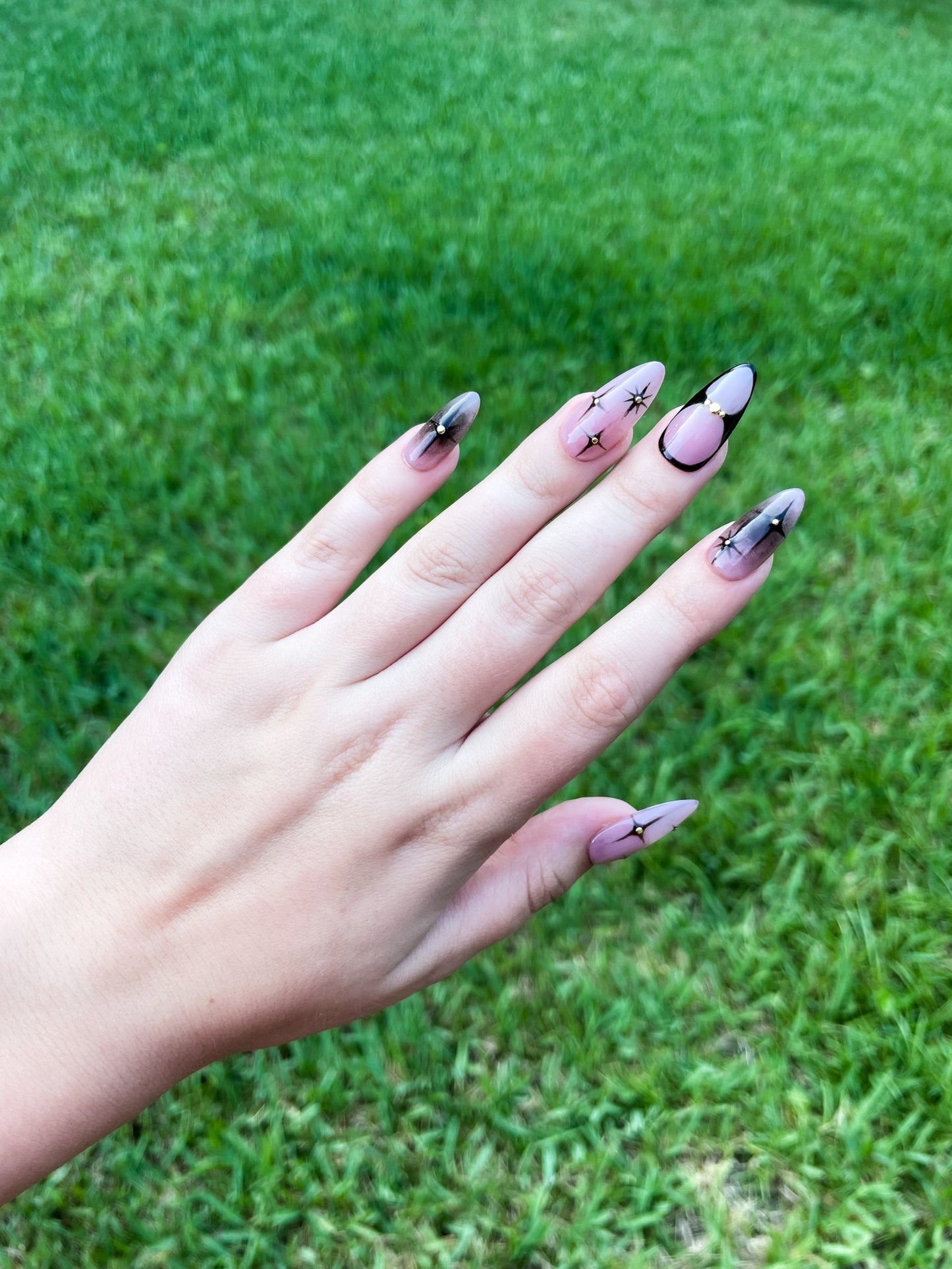 Starry Night Almond press-on nails with deep black and sparkling star accents in an elegant almond shape